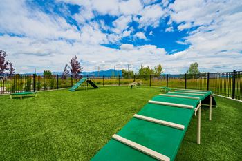 a view of a playground with benches on the grass